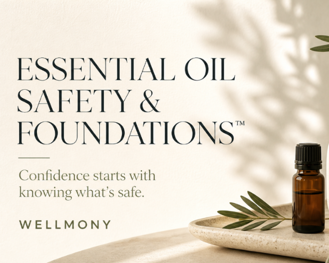 Wellmony essential oil guide beside an amber oil bottle and olive leaves in warm natural light.